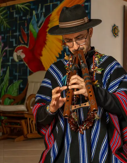 Yagecero Sergio Henao playing the flute in the ceremony room at Harmonica Retreat