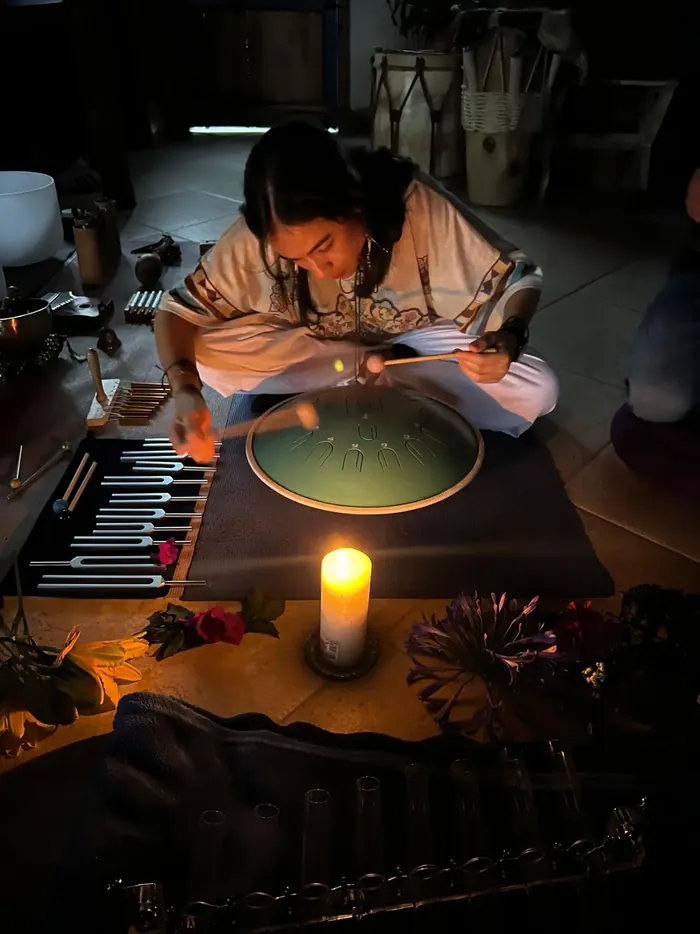 Harmonica Ayahuasca Retreat Colombia Candlelit sound healing A facilitator playing a handpan during sound healing by candlelight