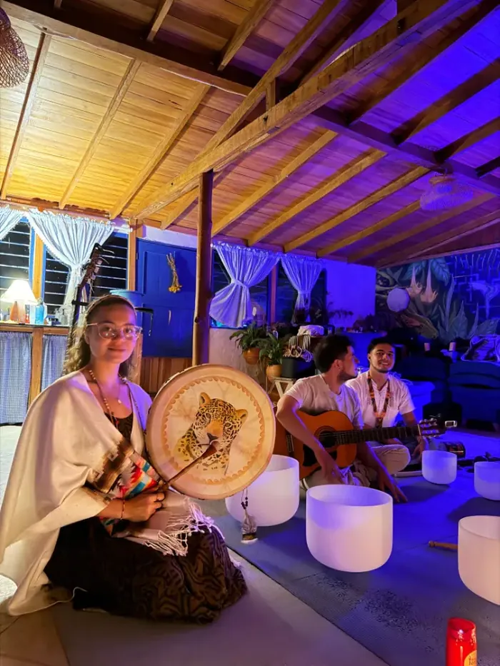 Harmonica Ayahuasca Retreat Colombia Drum and crystal bowls A woman with a painted drum and crystal singing bowls