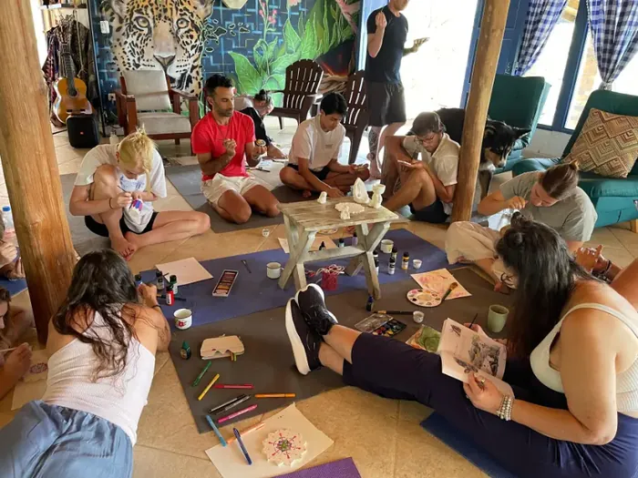 Harmonica Ayahuasca Retreat Colombia Group art session Participants painting and drawing together on the floor during an art session