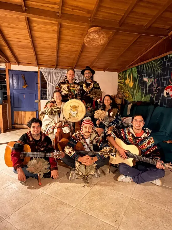 Harmonica Ayahuasca Retreat Colombia Group with guitars The group sitting together with guitars and a painted drum