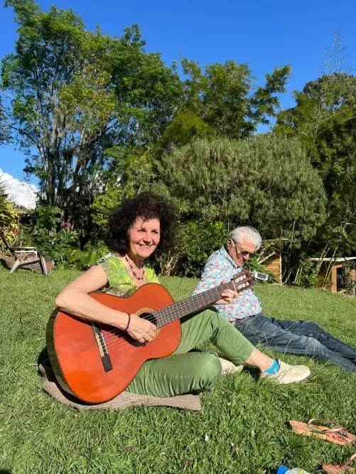 Harmonica Ayahuasca Retreat Colombia Guitar on the grass A participant playing guitar on the grass in the sunshine