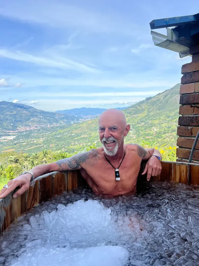 Harmonica Ayahuasca Retreat Colombia Ice bath with view A participant smiling in the ice bath with a view of the valley