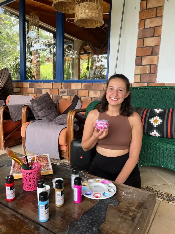 Harmonica Ayahuasca Retreat Colombia Painting on the porch A participant smiling with a painted object on the porch