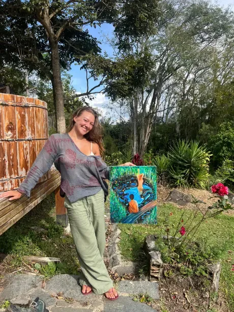 Harmonica Ayahuasca Retreat Colombia Showing a painting A participant showing her finished painting in the garden